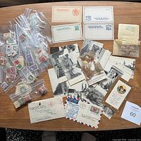 Photo showing assortment of vintage postcards depicting early 20th century Paris and WW1 era scenes alongside unused postal cards and airmail envelopes.