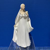 Front view of the Royal Doulton bride figurine, showing the full figure in white gown with gold detailing and holding a rose.