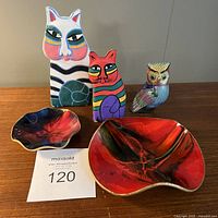 View of lot contents showing two colorful vintage MCM glass bowls with leather backing and three decorative figures: two painted MCM style cats and cloisonné owl figurine