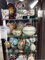 All three glass shelves filled with decorative eggs and a chick egg cup