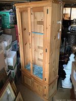 Front and side view of large solid pine cabinet with double glass doors and lower storage doors.