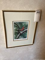 Framed Northern Cardinal print matted and hung on a wall showing full view including frame and mat.