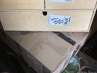 Wooden drawer closed labeled 'Bottom drawer contents only' with sticker number 378.