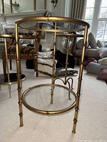 Side view of the smaller gold bamboo style metal side table showing glass top and base
