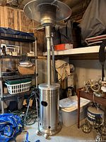 Side view of assembled stainless steel Fire Sense patio heater standing in garage.