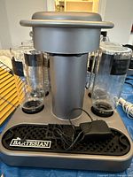 Front view of Bartesian cocktail machine with four mixing beakers and power adapter