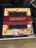 Front view of Monopoly Luxury Edition box and game board showing oversized wooden cabinet board and packaging.