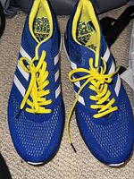 Top view of Adidas men's running shoes size 11, blue with white stripes and yellow laces