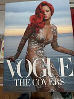 Vogue: The Covers coffee table book cover showing a woman with red hair in a detailed sheer dress