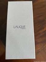 White textured box with ‘LALIQUE PARIS’ logo on lid