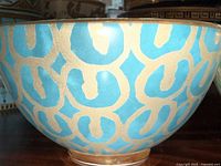 Medium close-up of a turquoise and gold geometric patterned L’Objet decorative bowl