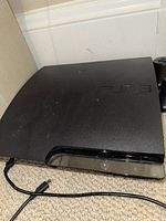 PS3 Slim console top and front view with power cable