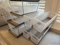 Stack of 3 white perforated plastic baskets with metal frame for stacking, showing front and side profiles