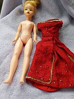 Full body view of nude Ideal Tammy doll next to red dress showing size and condition.