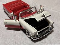 Close-up photo showing the front and interior of the Danbury Mint 1955 Oldsmobile Super 88 model car with open driver door and hood.