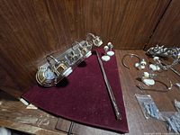 Photo shows a metal light bar with three adjustable brass-colored fixtures on chrome base, chrome towel bar, paper holder, towel rings, two ceramic robe hooks, and hardware bags.