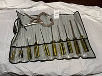 Full view of gray pouch containing 10 Pratt Read screwdrivers with yellow and black handles, laid out on white surface.