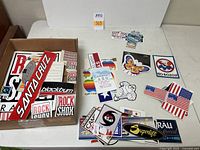 Overview of various decals arranged inside and next to a box. Includes Rock Shox, Santa Cruz, Blackburn, Superlift, and more.