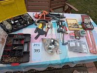 Overview of all tools and hardware laid out on table including clamps, scrapers, paint brushes, and hardware organizer boxes.