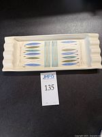 Top view of rectangular ceramic ashtray showing Mid-Century Modern geometric leaf design in blue and green.