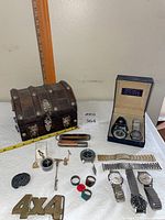 Overall lot shot showing chest, belt buckle, knives, rings, pins, bolo slide, compass, watches