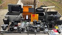 Overview of all four cameras, cases and accessories laid out on table