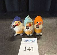 Set of three holiday elf figurines on black background with inventory label, showing different colored hats, pipes, white beards, glasses, and red noses.