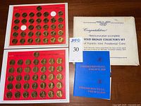 Red coin display boards with Franklin Mint Presidential Hall of Fame coins, some coin slots empty for one incomplete set