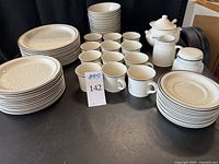 Set of dinner plates, salad plates, cups, saucers, creamer, sugar bowl, and sauce tureen arranged with number label