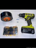 Ryobi cordless drill, DeWalt bit set case closed, and roll of black Gorilla tape displayed on table.