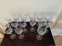 Top-down view of all 15 Gorham Crystal wine glasses arranged in rows, showing the etched diamond cut pattern on the bowls.