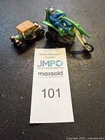 Photo showing both the green Hot Wheels Sizzlers Chopcycles Mighty Zork with rider and the vintage Ford Model T toy car side by side.