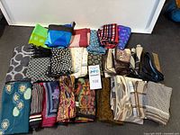 Large assorted pile of vintage scarves folded, showing variety of colors and textures
