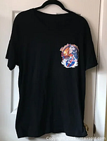 Front view of black large T-shirt with small colorful skeleton graphic on chest