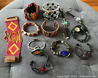 Full view of all 12 assorted bracelets with various styles and colors on a gray fabric surface