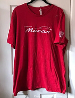 Full view of red Porsche Macan t-shirt on hanger showing front design and sleeve patch.
