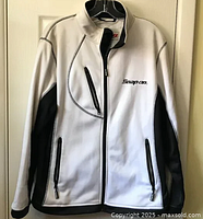 Front view of white Snap-On Tools jacket with three zip pockets and black side panels showing the logo on chest and zipper pulls.