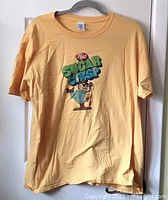 Full front view of yellow Sugar Crisp T-shirt on hanger showing overall condition and design.