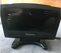 Front view of Westclox alarm clock radio showing large dark digital display and brand logo.