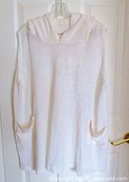 Front view of white mesh sleeveless coverup hoodie hanging on a hanger, showing length and roomy fit with terrycloth hood and pockets.