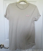 Full view of beige short-sleeve t-shirt on a hanger, showing color, fit and neckline.