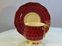 Cherry red Royal Albert teacup placed inside matching saucer showing front view