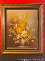Framed still life oil painting of a bouquet of yellow and white flowers in a beige vase.