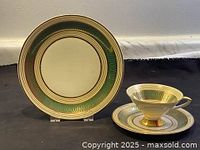 Full view of the cake plate standing upright showing the intricate green and gold pattern on cream background