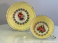 Image of tea cup and saucer showing front view and floral pattern with silver inlaid details