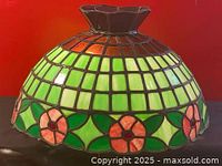 Front and side view of the dome-shaped stained glass lamp shade showing the floral design, color pattern and structure.