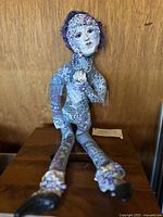 Front view of Blue Monday mixed media ceramic doll with detailed blue and purple mosaic patterns and floral motifs.