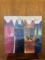 Front view of square canvas art panel showing colorful stylized cats and signature.