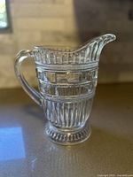Side view of clear cut glass pitcher showing geometric patterns and handle