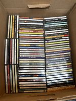 Full view of the jazz CD collection stacked inside a cardboard box.
